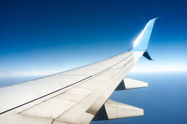Ala de um avião voando acima da terra — Fotografia de Stock