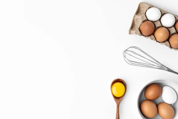 Свежие яйца с венчиком на белом фоне — стоковое фото