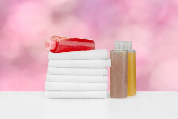 Spa still life with towels and skincare cosmetics against blurred background — Stock Photo, Image
