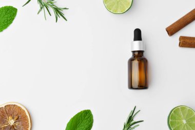 Beyaz arka planda gerekli yağ şişeleri ve narenciye meyvesi