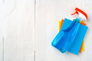 Beyaz ahşap arka planda ev temizlik malzemeleri, üst manzara.