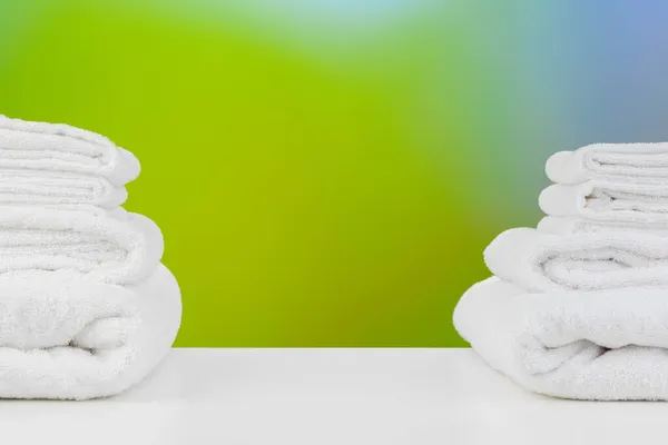 Toallas de spa blancas apiladas en la mesa contra fondo borroso — Foto de Stock