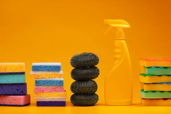 Detergenty i gąbki do czyszczenia dla gospodarstw domowych na żółtym tle — Zdjęcie stockowe