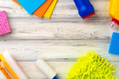 Beyaz ahşap arka planda ev temizlik malzemeleri, üst manzara.