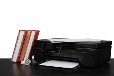 Yazıcı ile çalışma masası ve beyaz çekmeceler üzerine istiflenmiş kitaplar