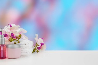 Bulanık arkaplana karşı ışıklı masada çiçekli havlular