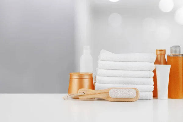 Spa still life with towels and skincare cosmetics against blurred background — Stock Photo, Image