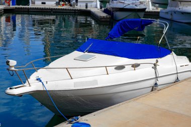 İskeleye park edilmiş küçük lüks bir tekne.
