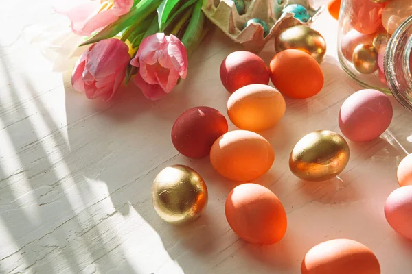 Yumurta kutusuna boyanmış Paskalya yumurtaları ve taze laleler. — Stok fotoğraf