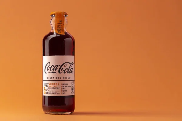 KRASNODAR, ΡΩΣΙΑ - 12 ΟΚΤΩΒΡΙΟΥ 2020: Γυάλινη φιάλη με μίξερ υπογραφής Coca-Cola σε πορτοκαλί φόντο — Φωτογραφία Αρχείου