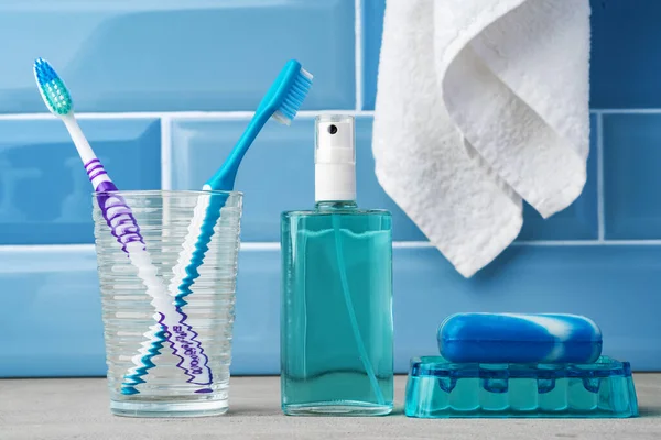 Szczoteczki do zębów w szklance w niebieskiej łazience. — Zdjęcie stockowe