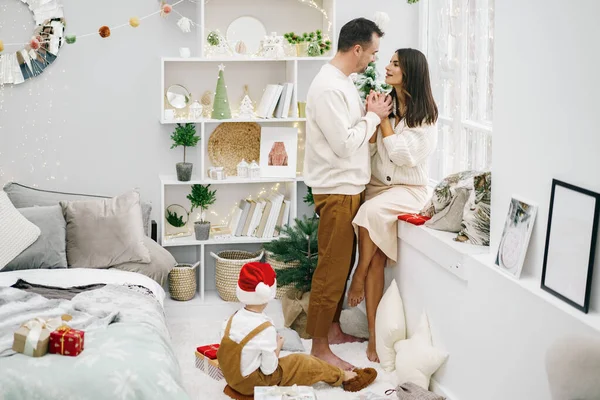 Ebeveynleri ve küçük oğulları Noel zamanı evde eğleniyor ve oyun oynuyorlar.