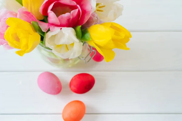 Flores frescas da primavera com ovos pintados para a celebração da Páscoa — Fotografia de Stock