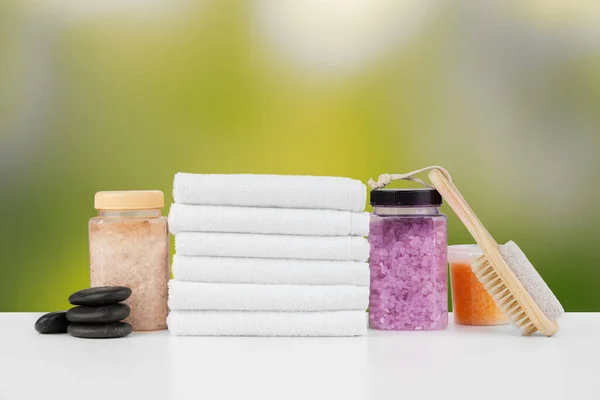 Various spa beauty threatment products and towels against blurred background — Stock Photo, Image