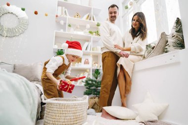 Ebeveynleri ve küçük oğulları Noel zamanı evde eğleniyor ve oyun oynuyorlar.