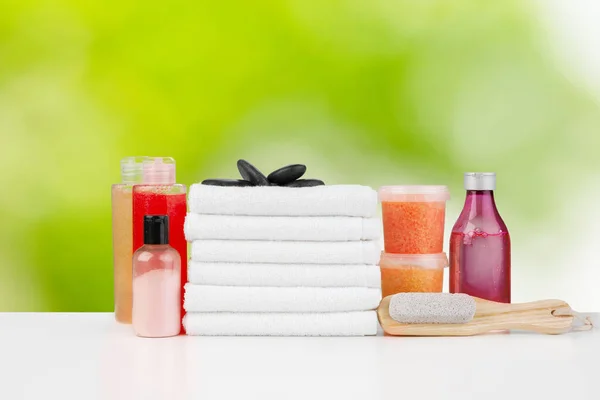 Lázeňský zátiší s ručníky a kosmetikou pro péči o pleť na rozmazaném pozadí — Stock fotografie