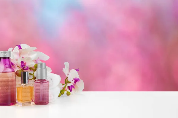 Bulanık arkaplana karşı ışıklı masada çiçekli havlular — Stok fotoğraf