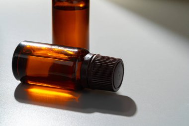 Kozmetik için kehribar cam şişeler, doğal ilaçlar veya gri arka planda gerekli yağlar