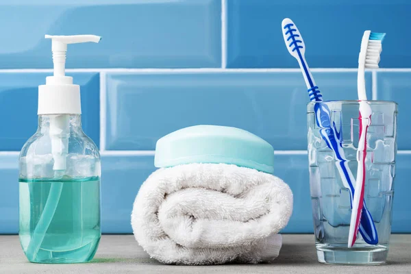As escovas de dentes em um copo no banheiro azul. — Fotografia de Stock