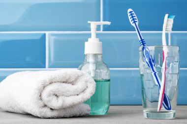 Mavi banyodaki bardaktaki diş fırçaları..