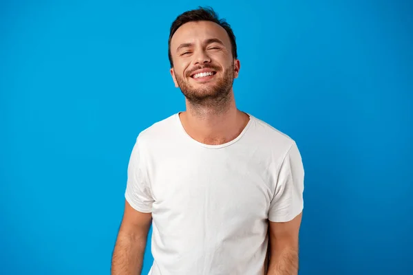 Glücklich lächelnder schöner Mann vor blauem Hintergrund — Stockfoto