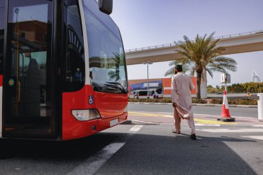 DUBAI, BAE - 15 Mart 2021: Kırmızı şehir otobüsü Dubai, BAE 'de bir sokakta sürüyor.
