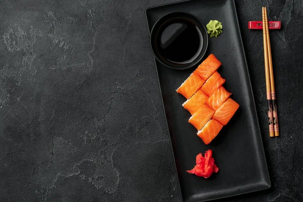 Čerstvé filadelfské sushi rolky podávané na černém talíři — Stock fotografie