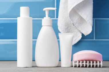 Sabun ve tuvalet malzemeleri mavi banyoda rafta.