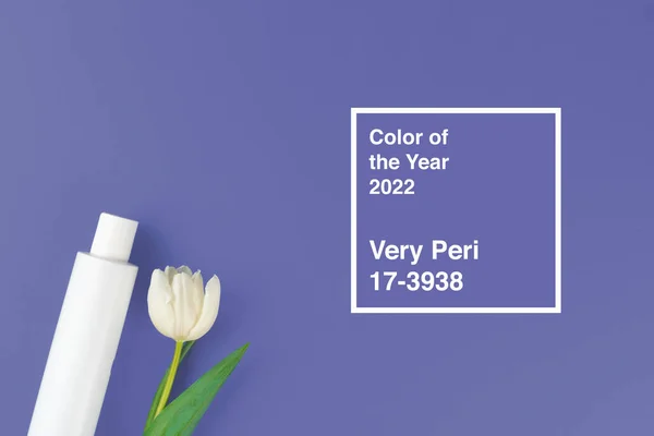 Draufsicht auf weißen Kosmetikbehälter mit Blume auf lila Hintergrund — Stockfoto