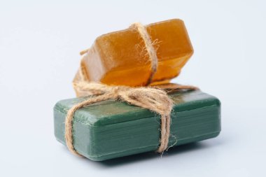 Beyaz üzerine izole edilmiş kurdeleyle bağlanmış doğal sabun çubukları.