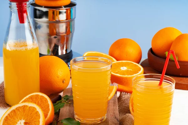 Bottle of orange juice and fresh oranges on table — Stock Photo, Image