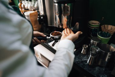 Kahve dükkanındaki müşterilere kahve hazırlayan baristaların ellerini kapat.