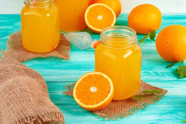 Yeşil ahşap masadaki portakal suyu dolu bardak.