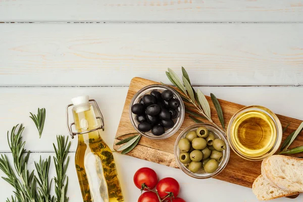 Oliwa z oliwek, oliwki i pomidory na drewnianym tle — Zdjęcie stockowe