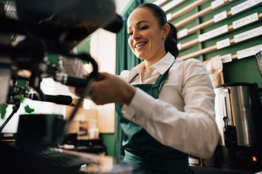 Kafkas kadın barista iş yerinde kahve yapıyor.