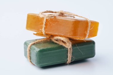 Beyaz üzerine izole edilmiş kurdeleyle bağlanmış doğal sabun çubukları.