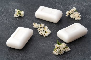 Koyu gri arka planda sabunlar ve çiçekler