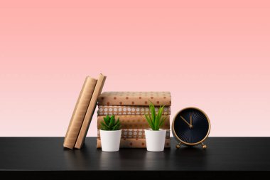 Siyah ahşap masada yığınla kitap.