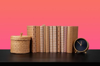 Siyah ahşap masada yığınla kitap.