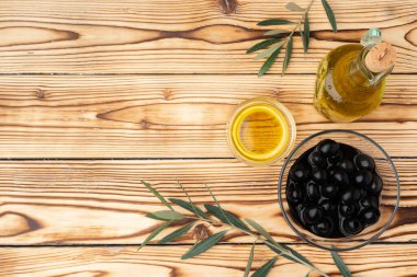 Ahşap zemin üzerinde zeytin ve bir şişe zeytin yağı.