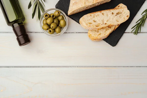 Włoski chleb ciabatta z oliwą z oliwek na drewnianym tle — Zdjęcie stockowe