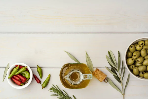 Oliwki i butelki oliwy z oliwek na drewnianym tle — Zdjęcie stockowe