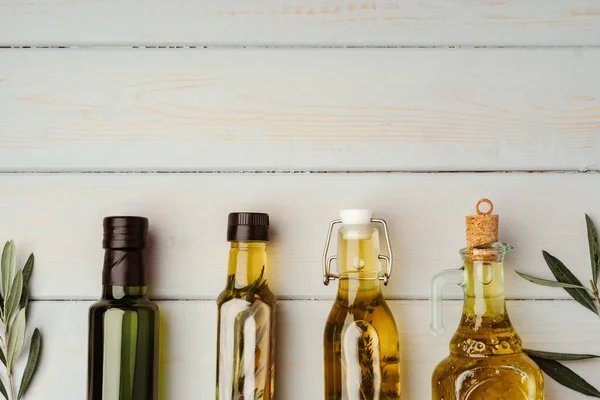 Glass bottle with olive oil on gray background — Stock Photo, Image