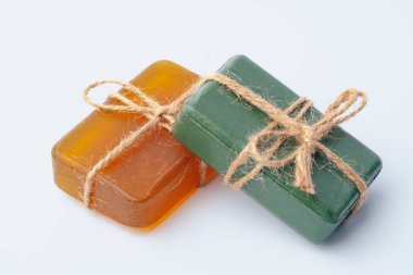 Beyaz üzerine izole edilmiş kurdeleyle bağlanmış doğal sabun çubukları.