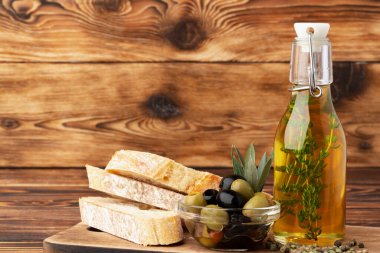 İtalyan ciabatta ekmeği ve ahşap zemin üzerinde zeytin yağı.