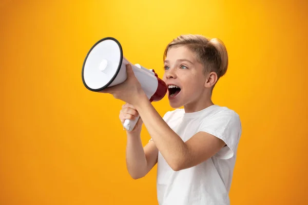 Little boy with megaphone on yellow background — 스톡 사진