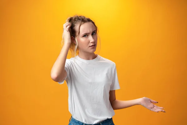 Young beautiful woman thinking looking to the side against yellow background — 图库照片