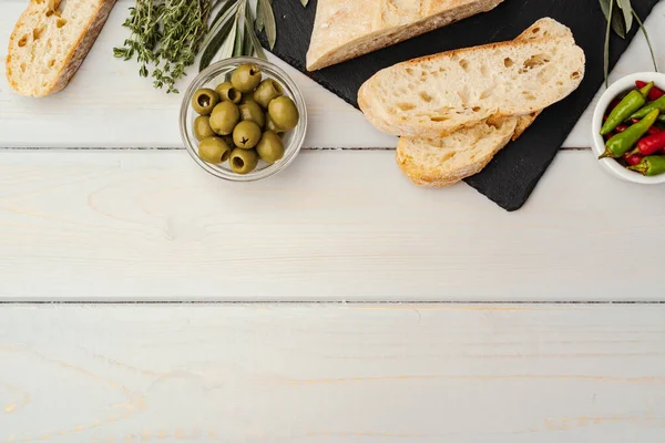 Włoski chleb ciabatta z oliwą z oliwek na drewnianym tle — Zdjęcie stockowe
