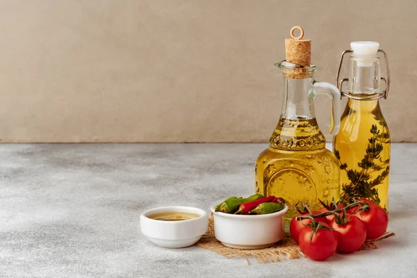 Azeite fresco natural em garrafa sobre mesa cinzenta — Fotografia de Stock