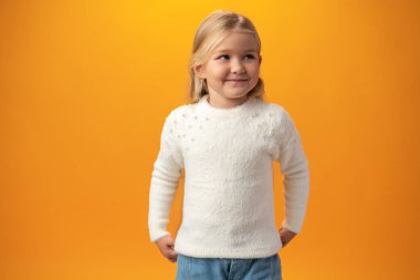 Beautiful blonde little girl portrait over yellow background